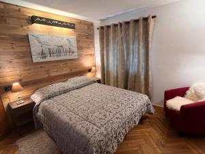 a bedroom with a bed and a red chair at Central Spacious Apartment, Mountain Views in Sauze d'Oulx