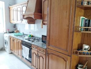 a kitchen with wooden cabinets and a stove top oven at Eco Mar - Cedeira in Cedeira +3 photos