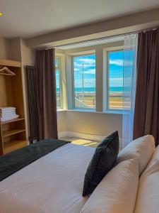 a bedroom with a large bed with a large window at Emerald Tide Hotel - Blackpool in Blackpool