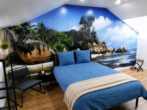 a bedroom with a blue bed and a mural of rocks at Le temps d'une pause -4- in Cepoy +8 photos