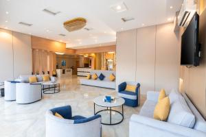 a lobby with couches and tables and a television at AlQasr - Almansak in Abha