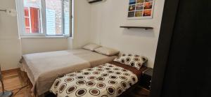 a small bedroom with a bed and a window at Medin BD in Budva