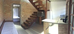 a kitchen with a staircase in a brick wall at Flats Vila Vitoria Residencial in Camburi