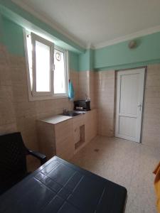 a small kitchen with a sink and a door at Andrea's hays in Kobuleti