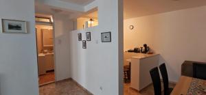 a kitchen and a dining room with a white wall at Medin BD in Budva