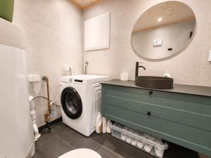 a bathroom with a washing machine and a sink at Architect designed sleeping box in barn in Nos
