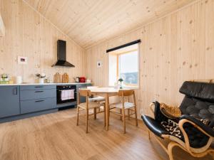 a kitchen with a table and chairs in a room at Architect designed sleeping box in barn in Nos