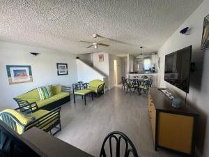 ein Wohnzimmer mit Sofa und Tisch in der Unterkunft Sunset Cove in Jolly Harbour