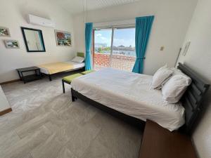 ein Schlafzimmer mit Bett und Fenster mit Aussicht in der Unterkunft Sunset Cove in Jolly Harbour