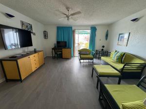 ein Wohnzimmer mit Sofa und Flachbildfernseher in der Unterkunft Sunset Cove in Jolly Harbour + 14 Fotos