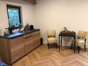 a kitchen with a sink and a table and chairs at B&B An de N35 in Zwolle