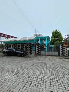 a car parked in front of a blue building at Andrea's hays in Kobuleti