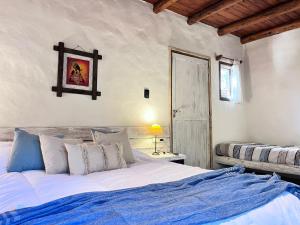 a bedroom with a large bed with a blue blanket at Pamayu Mar de Cobo in Mar de Cobo