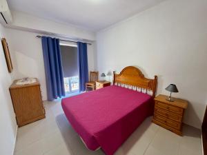 a bedroom with a pink bed and a window at Caravela B in Armação de Pêra +8 photos