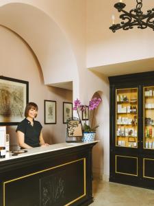 a woman is standing behind a counter in a restaurant at La Posta Vecchia Hotel in Ladispoli +102 photos