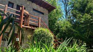 a house with a wooden staircase next to a building at Pamayu Mar de Cobo in Mar de Cobo