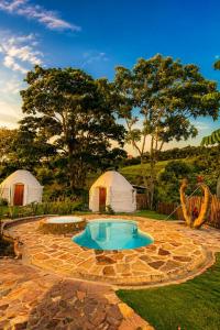 a backyard with a swimming pool and two tents at Aldea Ancestral by ID Hotel in Barbosa +34 photos