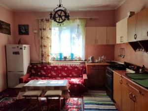 a living room with a red couch in a kitchen at BurshtynSV in Svityazʼ