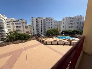 an apartment balcony with a swimming pool and buildings at Caravela B in Armação de Pêra