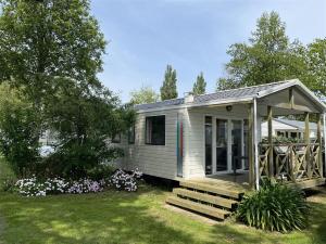 a tiny house with a porch and a deck at Camping Kost Ar Moor in Fouesnant