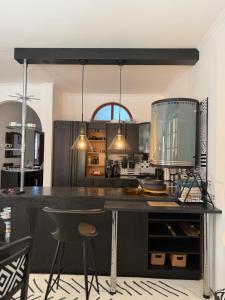 a kitchen with a large black counter and chairs at Apartmán Ela in Komárno