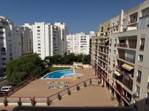 a pool in the middle of a city with buildings at Caravela B in Armação de Pêra