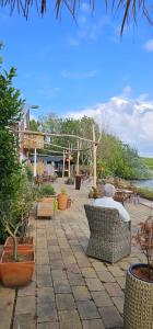 a patio with chairs and tables and potted plants at HotelPension van Ewijcksluis in Anna Paulowna