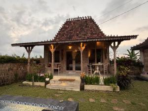 a gazebo with a table and chairs in a yard at Umaloka Eco Villa in Tirtagangga