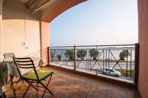 balkon z krzesłem i widokiem na samochód w obiekcie Holidays Pelion w mieście Nea Anchialos