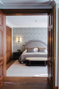 a bedroom with a large bed and a table at Suvretta House in St. Moritz