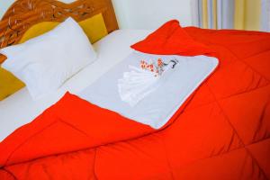 a red bed with a white shirt on it at KEFA Town Hotel in Kigali