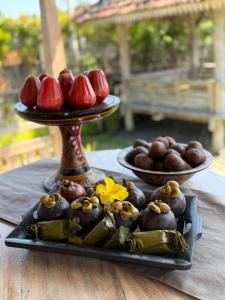 a plate of fruit and vegetables on a table at Umaloka Eco Villa in Tirtagangga
