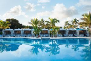 a resort swimming pool with tents and palm trees at South Seas in Captiva