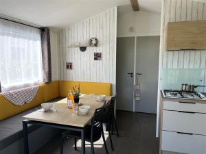 a kitchen with a table and chairs in a room at Camping Kost Ar Moor in Fouesnant