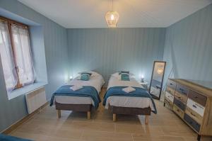 a bedroom with two beds with blue walls at Le gîte du château 2 in Crespy-le-Neuf +10 photos