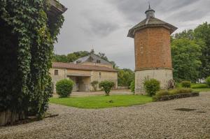 a house with a brick tower and a building at Le gîte du château 2 in Crespy-le-Neuf
