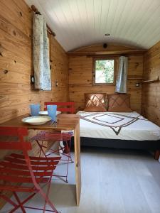 a bedroom with a bed and a table in a room at Maison Maliga J&G House in Saint-Pierre-de-Curtille