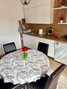 a kitchen with a table with a vase of flowers on it at Philippos in Bujanovac +19 photos