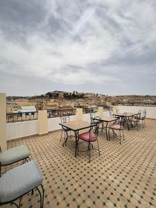 a group of tables and chairs on a roof at Riad Fes Colors & SPA - Family Lodging in Fez