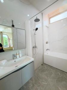 a bathroom with a sink and a tub and a mirror at Kharin guesthouse in Nakhon Phanom +13 photos