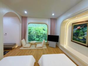 a bedroom with two beds and a large window at Kharin guesthouse in Nakhon Phanom