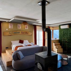 a bedroom with a fireplace and a bed and a couch at YAYLAMİSUN SUITE HOTEL Luxury Nature Stay Çamlıhemşin in Çamlıhemşin +52 photos
