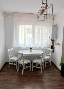 a white dining room with a white table and chairs at 4You in Cristuru Secuiesc