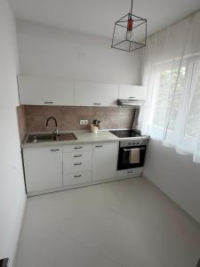 a white kitchen with a sink and a stove at 4You in Cristuru Secuiesc