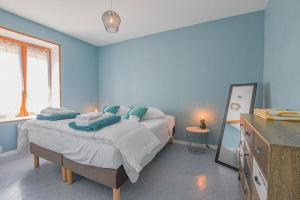 a bedroom with a large bed with blue walls at Le gîte du château 1 in Crespy-le-Neuf