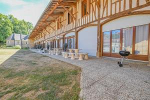 a row of tables and a grill in front of a building at Le gîte du château 1 in Crespy-le-Neuf