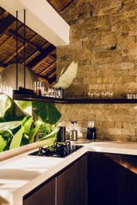 a kitchen with a stove and a brick wall at Nayma Villas in General Luna