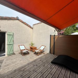two chairs sitting on a wooden deck at La Paloma in Aigues-Mortes