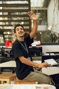 a man sitting at a desk with his hand in the air at Lisbon Destination in Lisbon