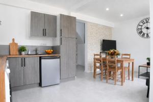a kitchen with wooden cabinets and a table with chairs at Le temps d'une pause -3- in Cepoy